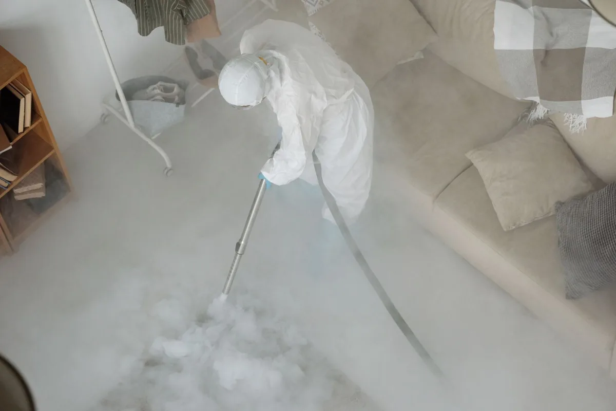 Biohazard cleanup technician in protective equipment, Rockwell Place, TX